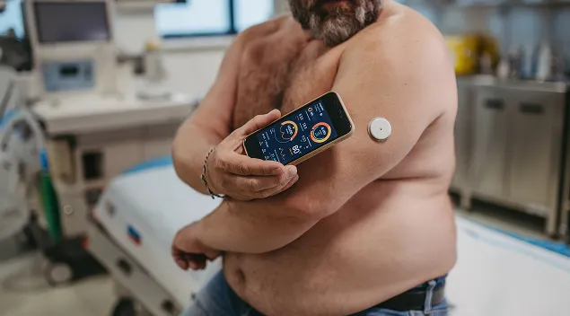 a man conducts the analysis through a sensor on his hand