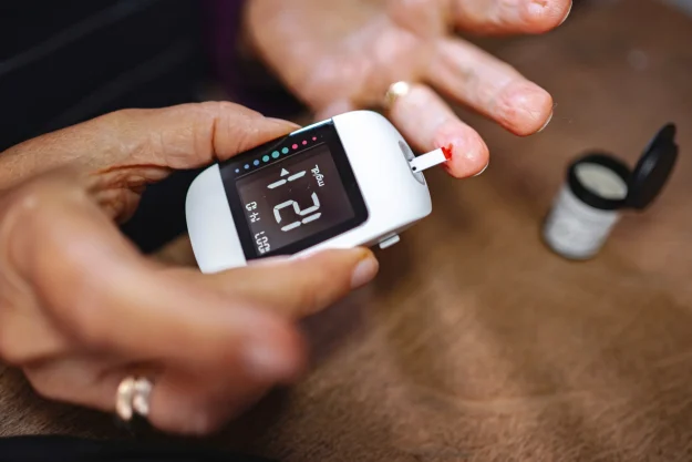 Person checking blood sugar with a glucometer during glucose monitoring