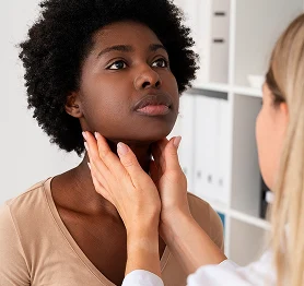 Doctor gently examining a young woman’s neck during a medical consultation in a clinic.